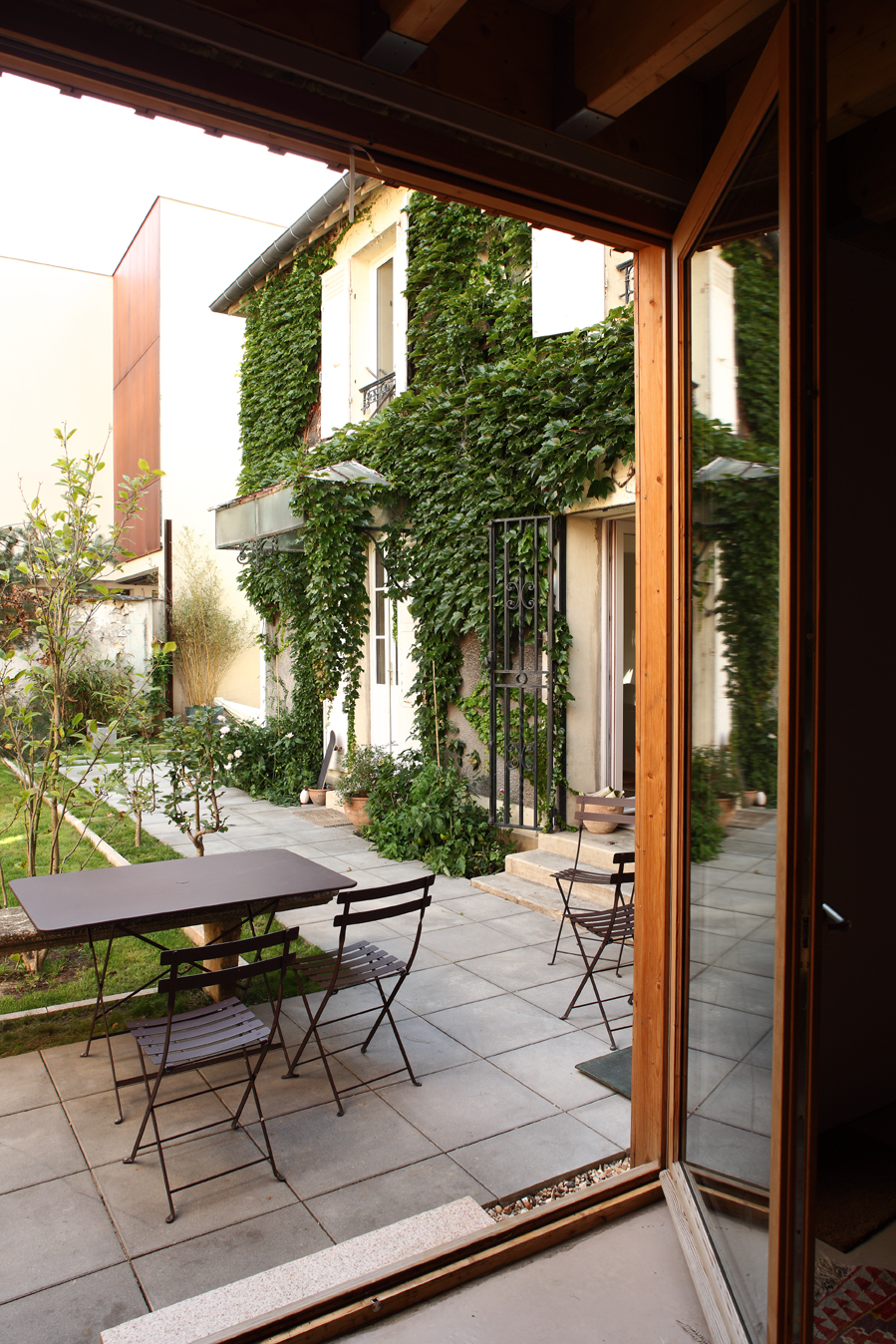 Terrace with bistro table looking back at the ivy-clad house