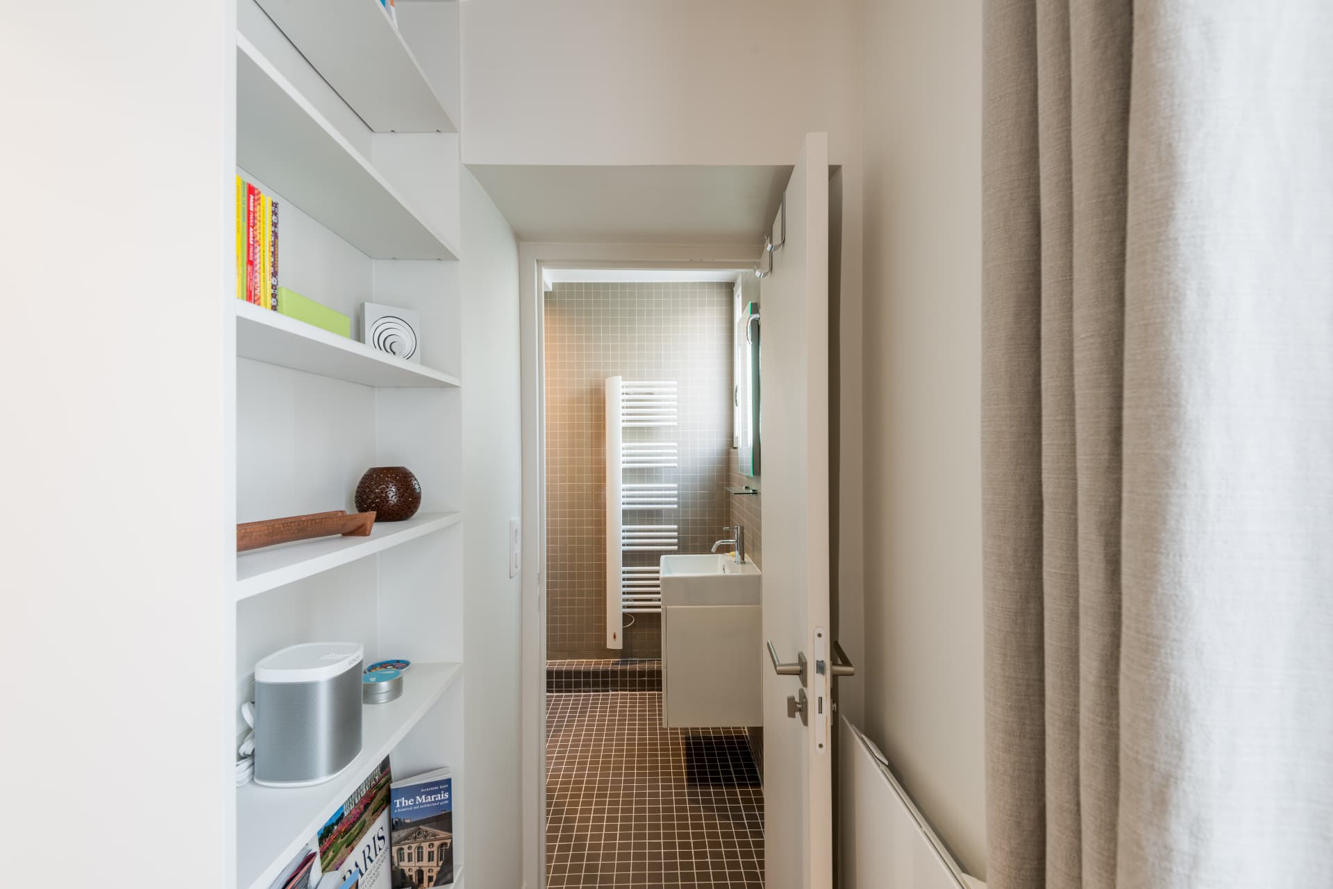 View from the hallway into the mosaic-tiled bathroom