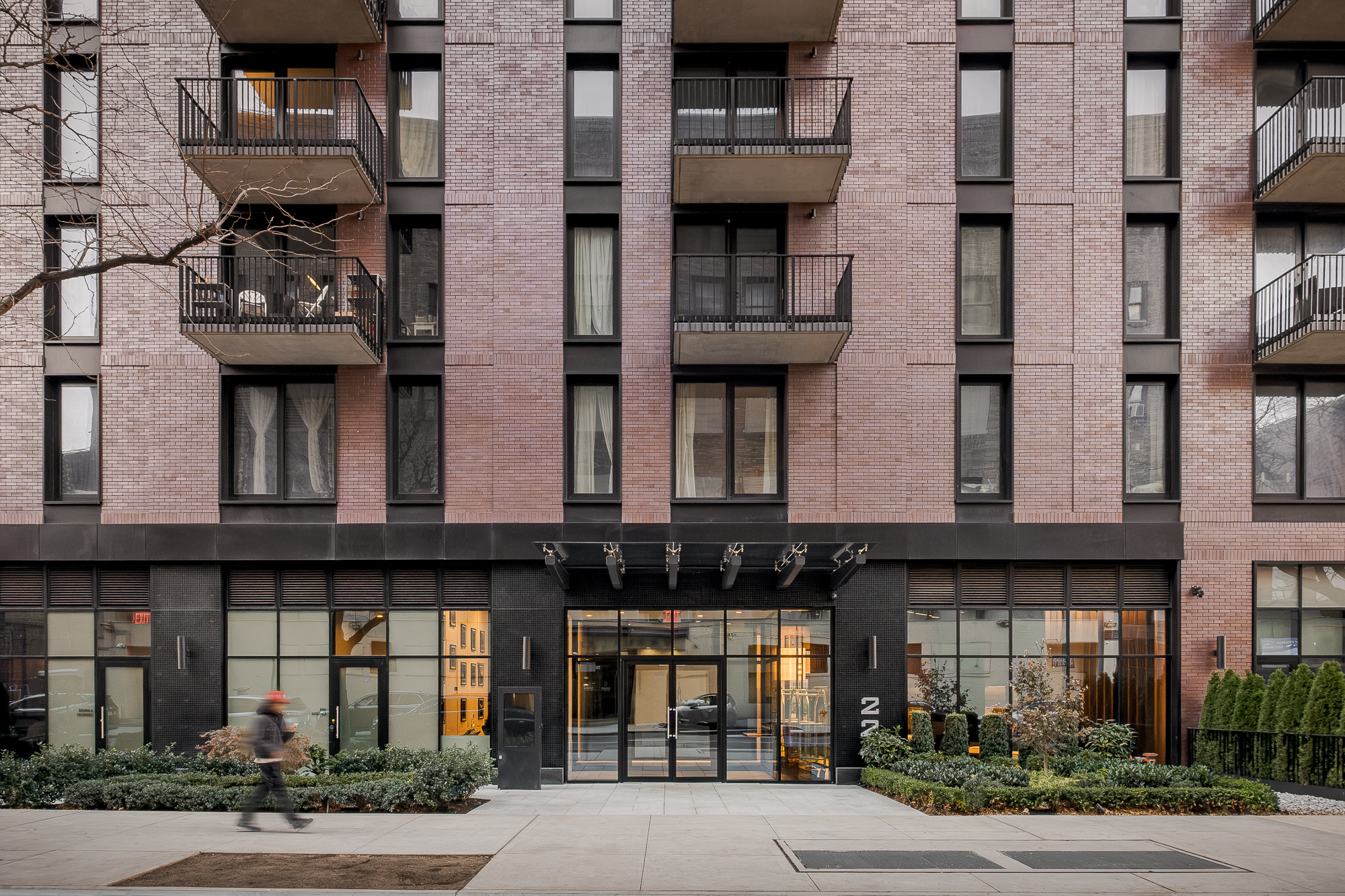 Street entrance of the 124th Street building with black brick base and canopy