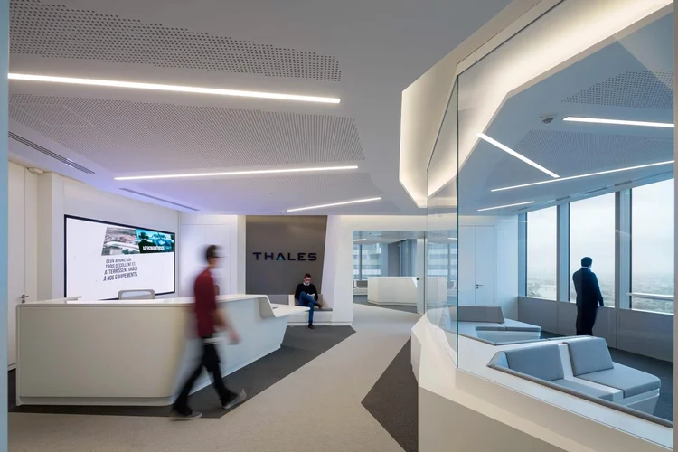 Thales headquarters reception with a sculptural white desk and the Thales logo beyond