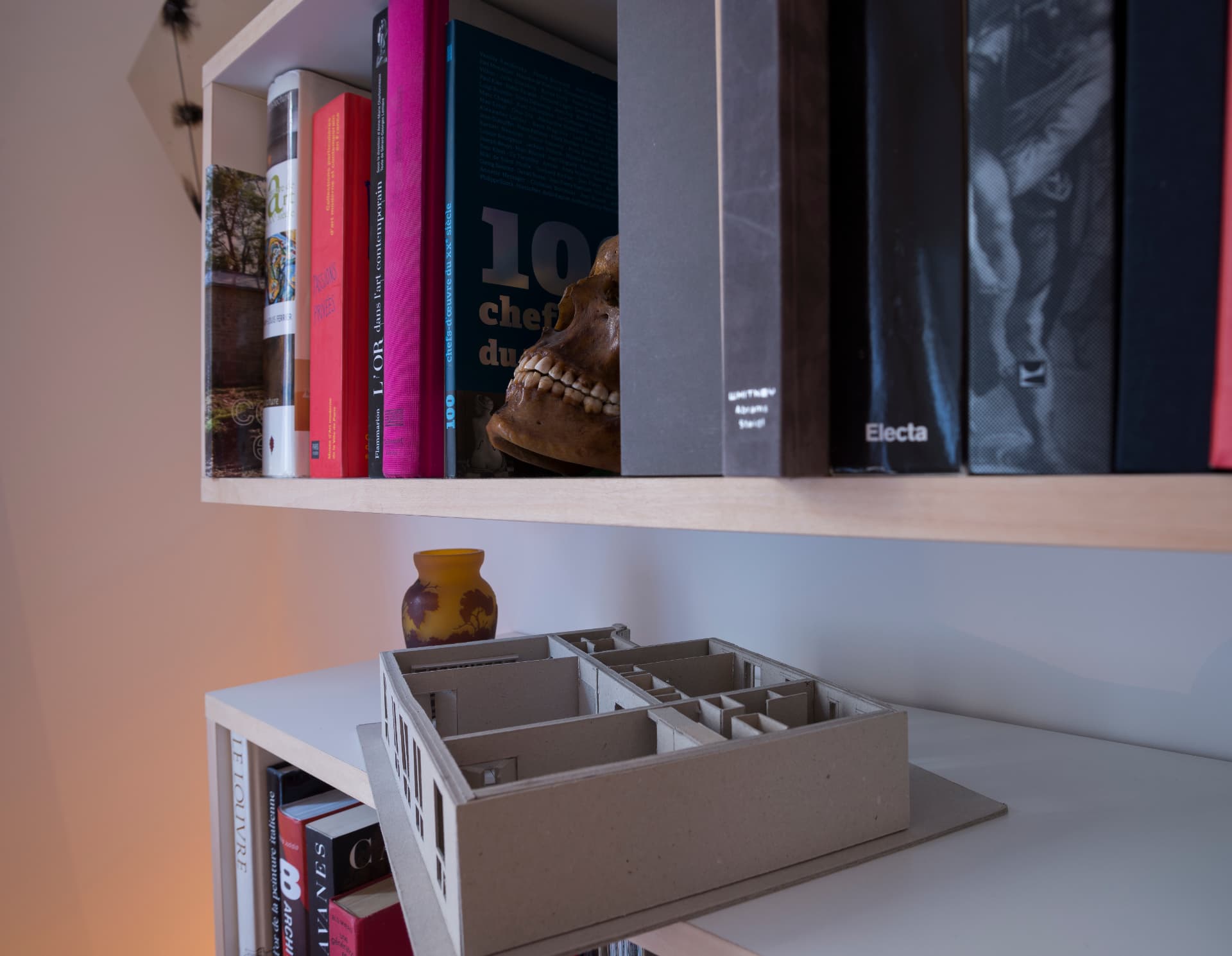 Study model of the apartment plan on a shelf with art books