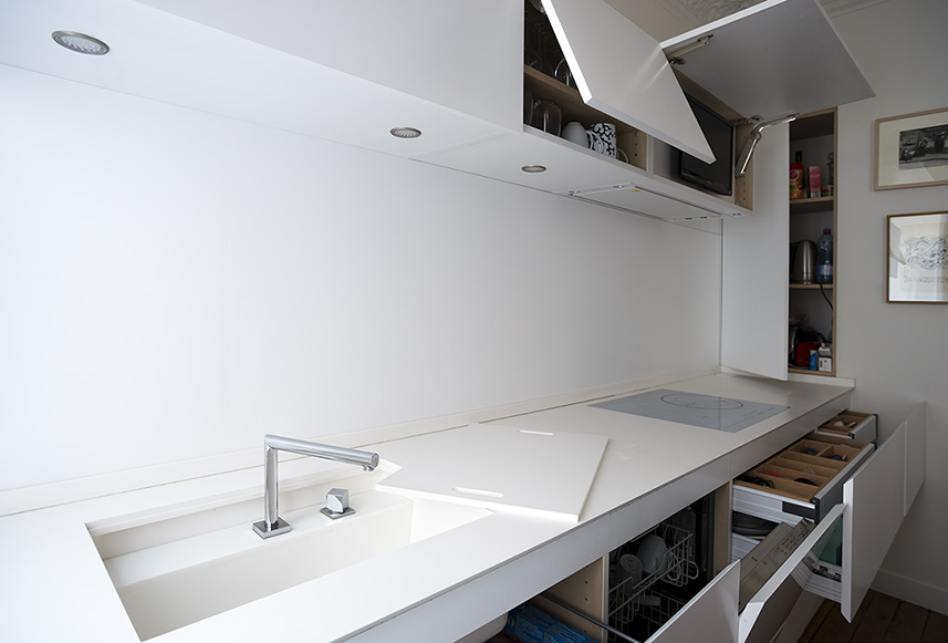 Seamless white kitchen with integrated sink, hob and lift-up cabinetry