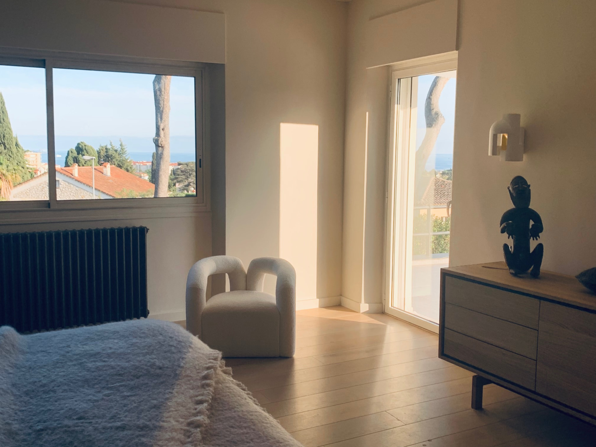 Bedroom with sea view, boucle chair and oak dresser