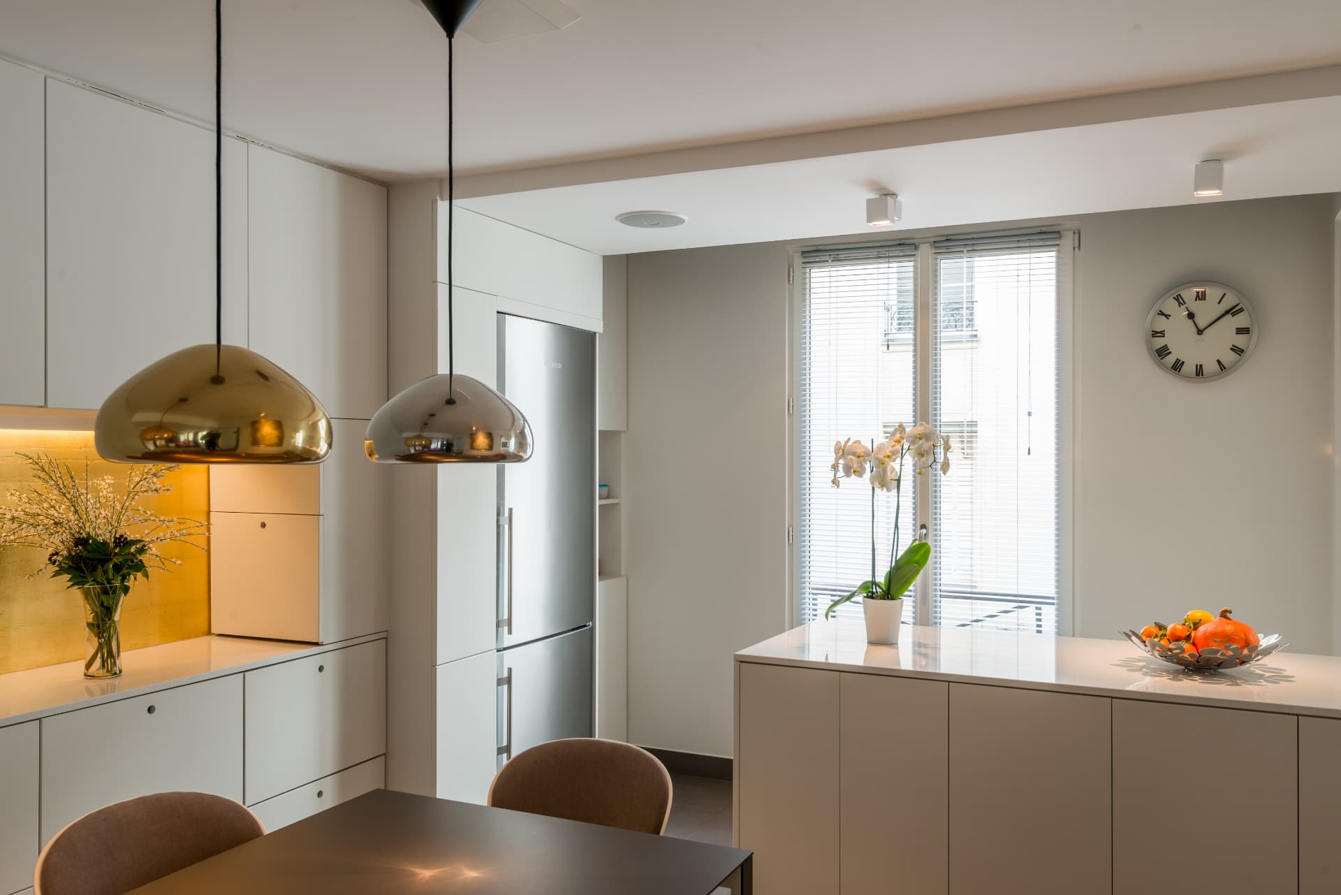 Dining corner beneath brass and copper pendant lamps