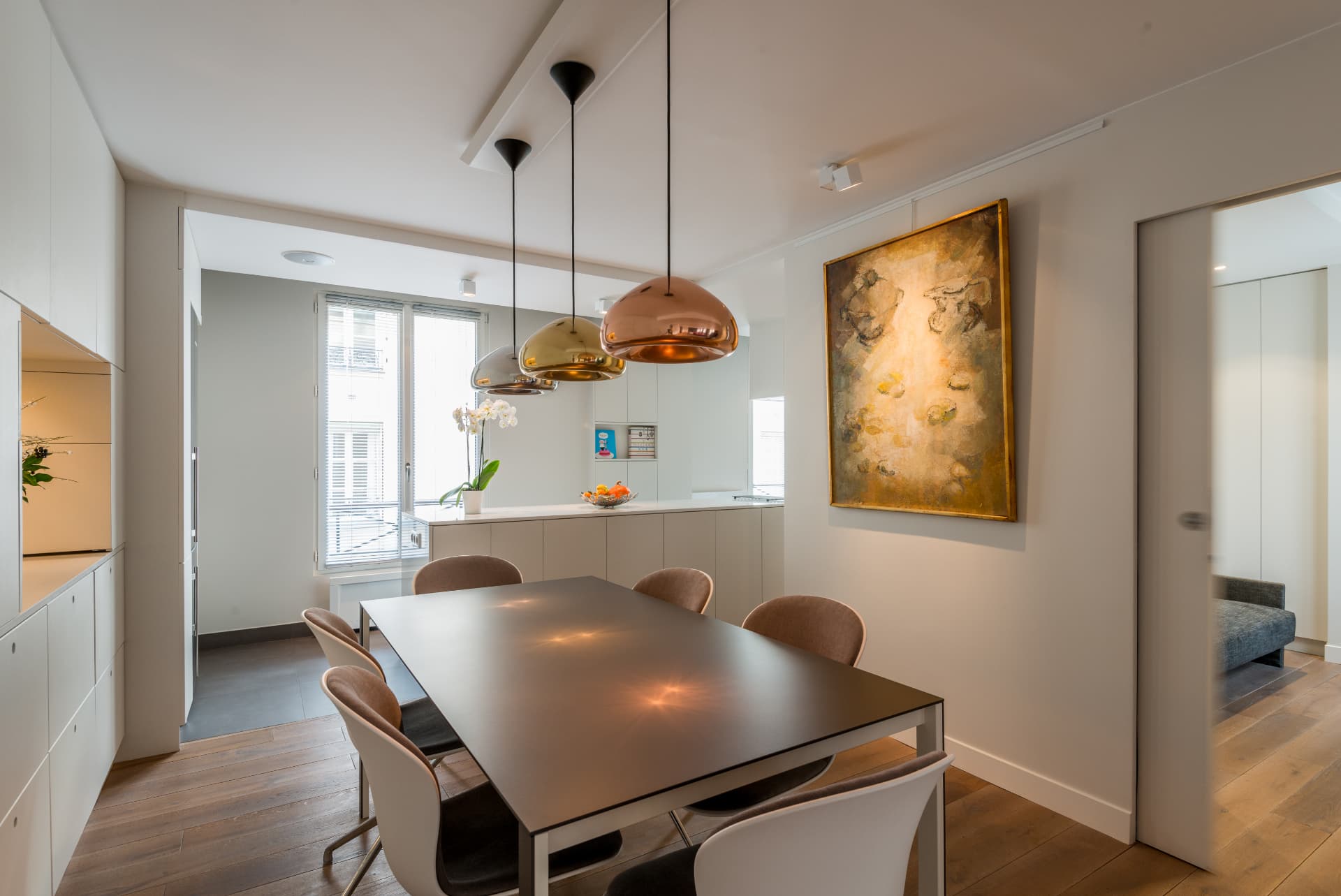 Dining room with a large portrait painting and brass pendant cluster