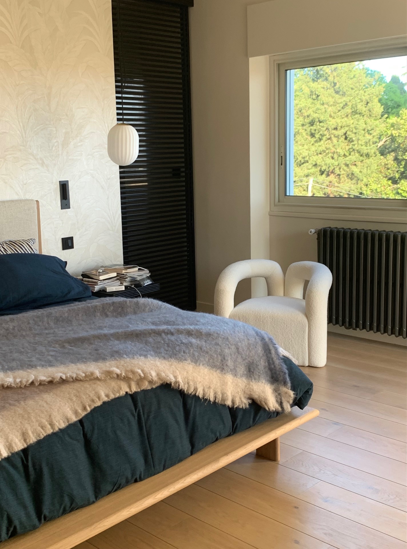 Bedroom with blue linens, shearling throw and oak bench