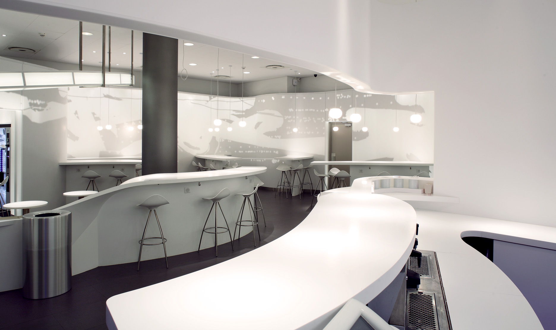 Sweeping white curved counters and bar stools in the Air France CE Ligne crew restaurant