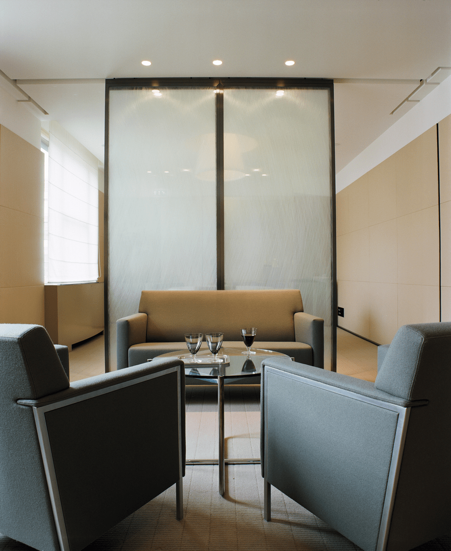 Air Liquide executive lounge with grey armchairs and frosted glass screen