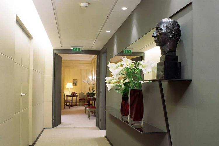 Air Liquide corridor with bronze bust, mirror and white lilies
