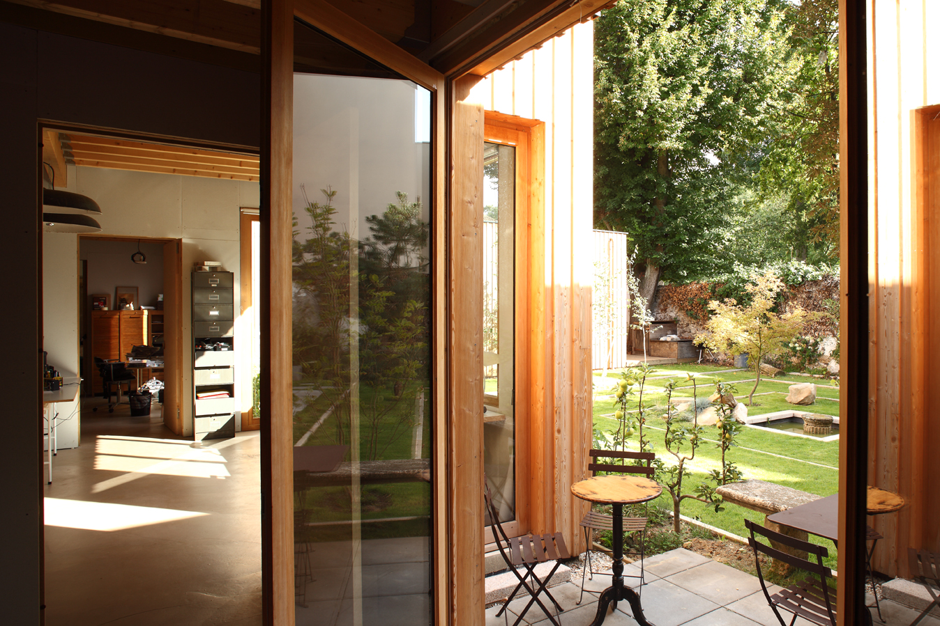 Folding glazed doors open from the studio interior onto the garden terrace
