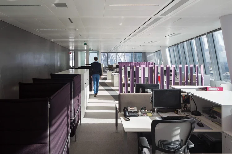 Thales open office floor with purple workstation screens and panoramic tower views