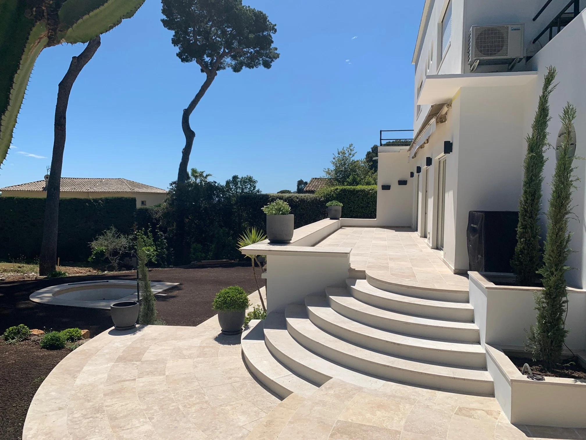 Curved stone steps rising from the garden to the villa terrace