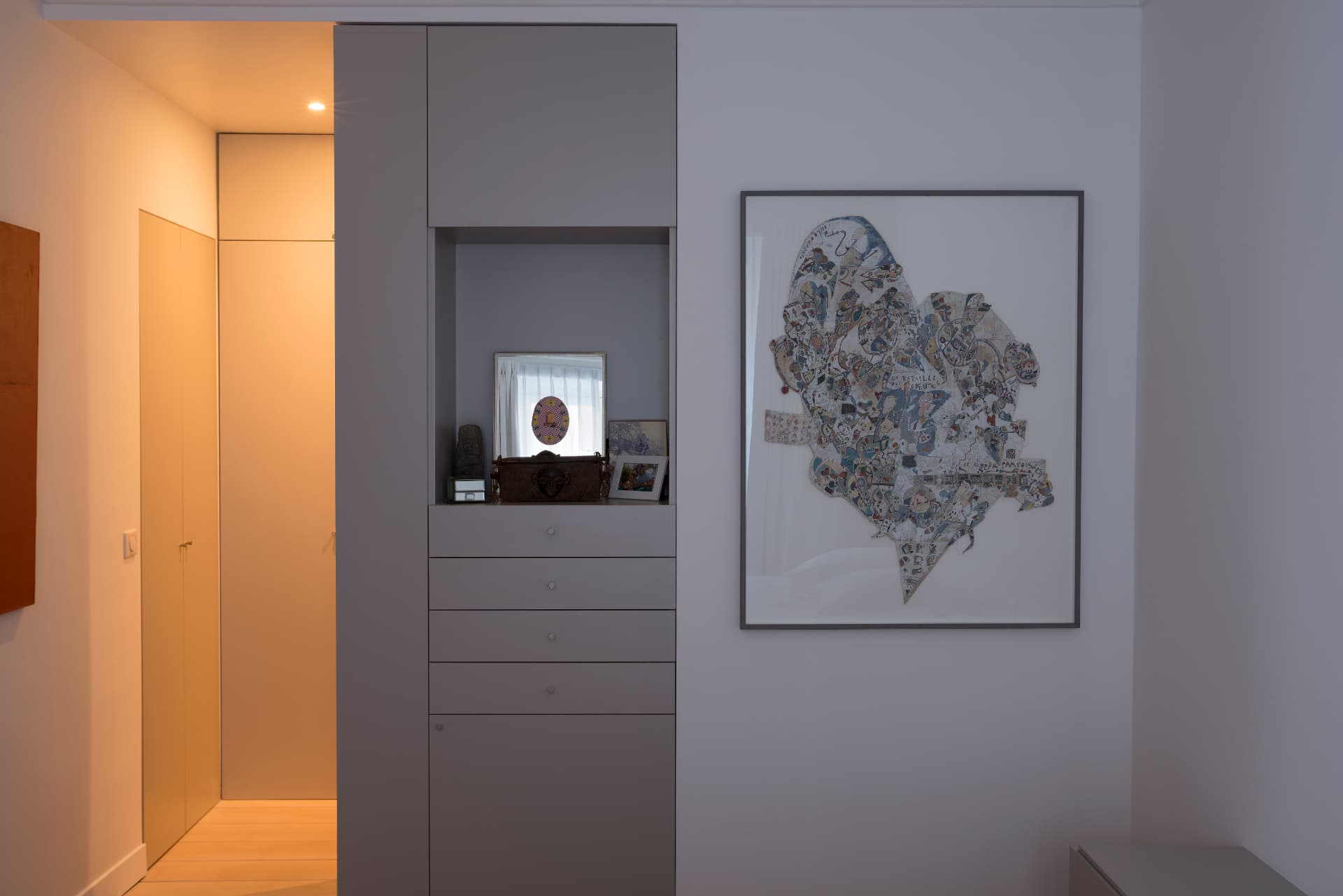 Bespoke grey joinery with niche, drawers and framed contemporary work