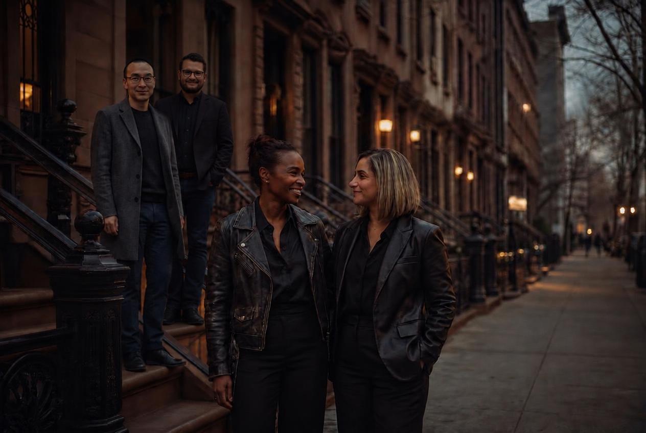 The FRED Interiors team — Anahay Peguero and Patricia Diaz on the sidewalk, Will Leung and Daniel Lyono Castellanos on the brownstone stoop behind them, at dusk in New York